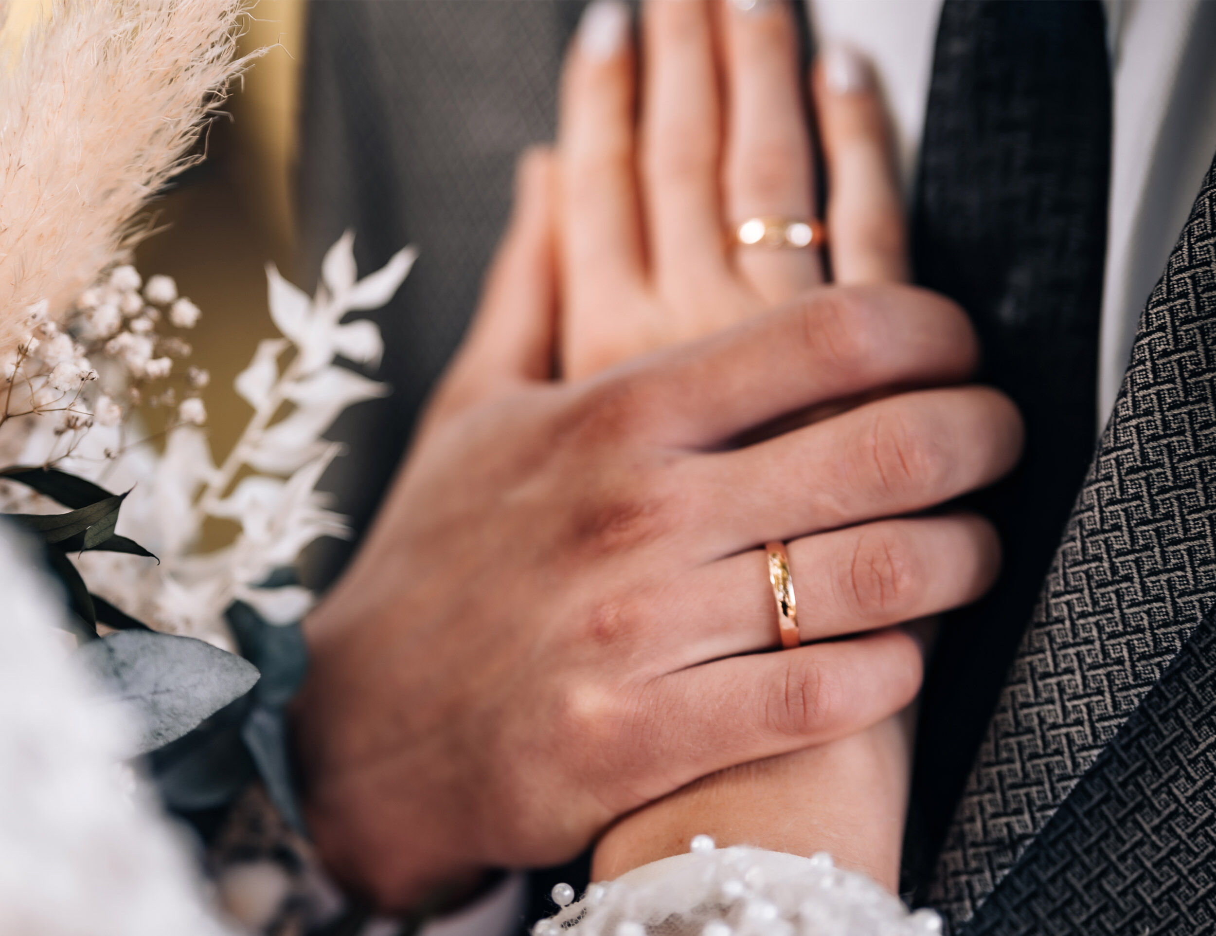 Couple holding hands, showing off wedding rings